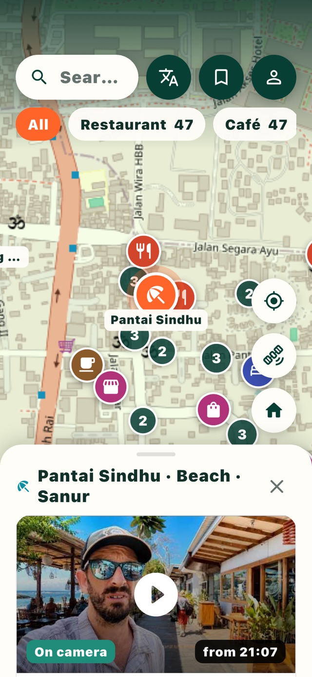 The Vayru app on an iPhone: Pantai Sindhu in Sanur on the map, with a Sanur Diaries creator moment from 21:07 below it.